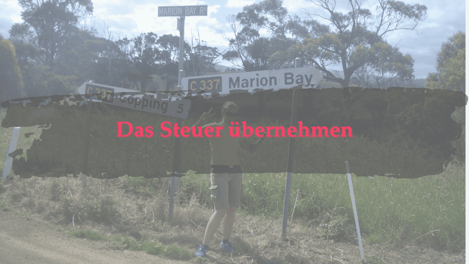 Marion Glück lachend in Australien vor einen Straßenschild mit der Aufschrift "Marion Bay"
